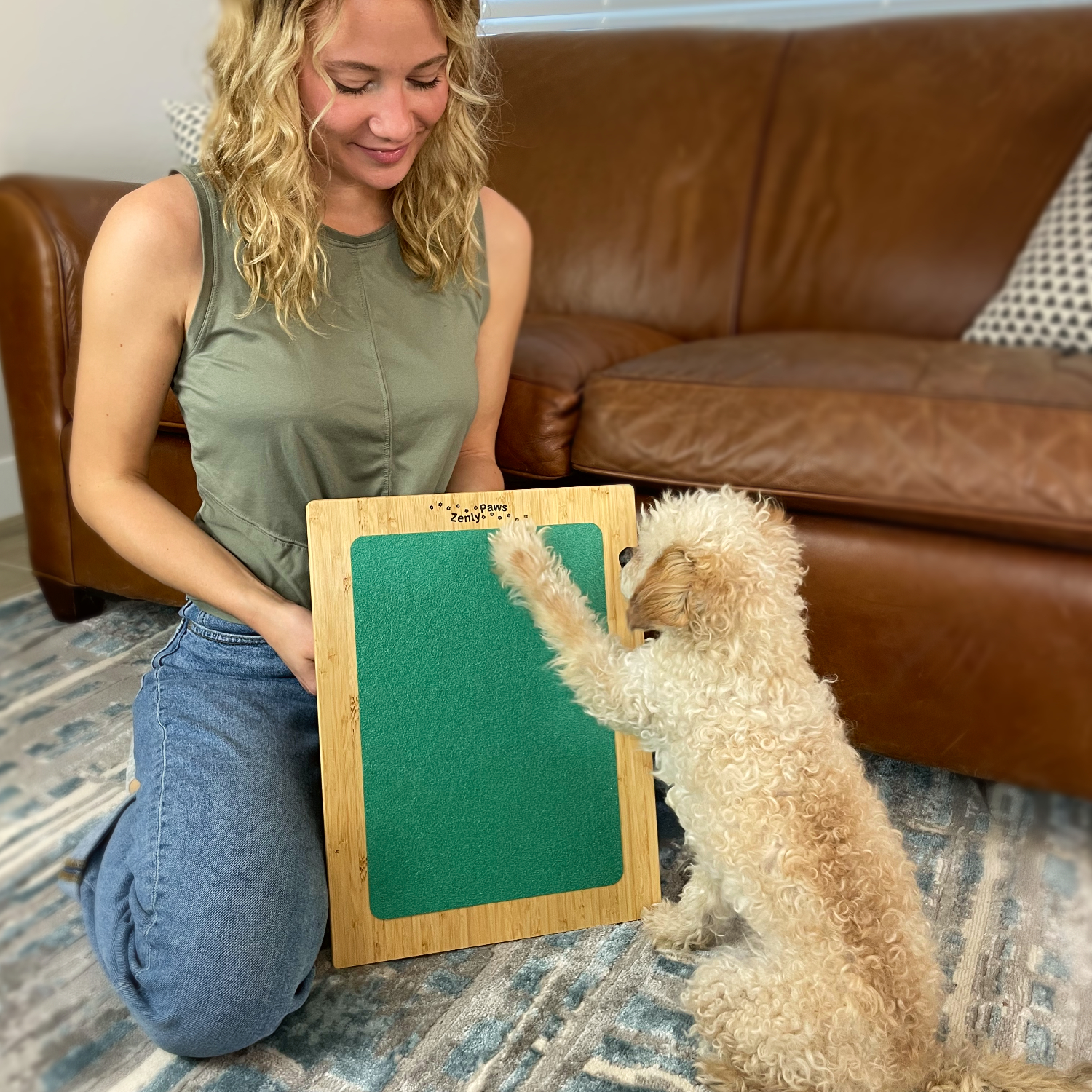 A Zenly Paws founder training a dog on the nail scratch board at home